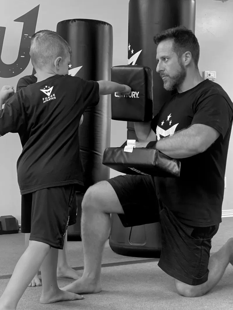 Young MMA students practicing striking techniques at Forge Athletics in Naples, FL