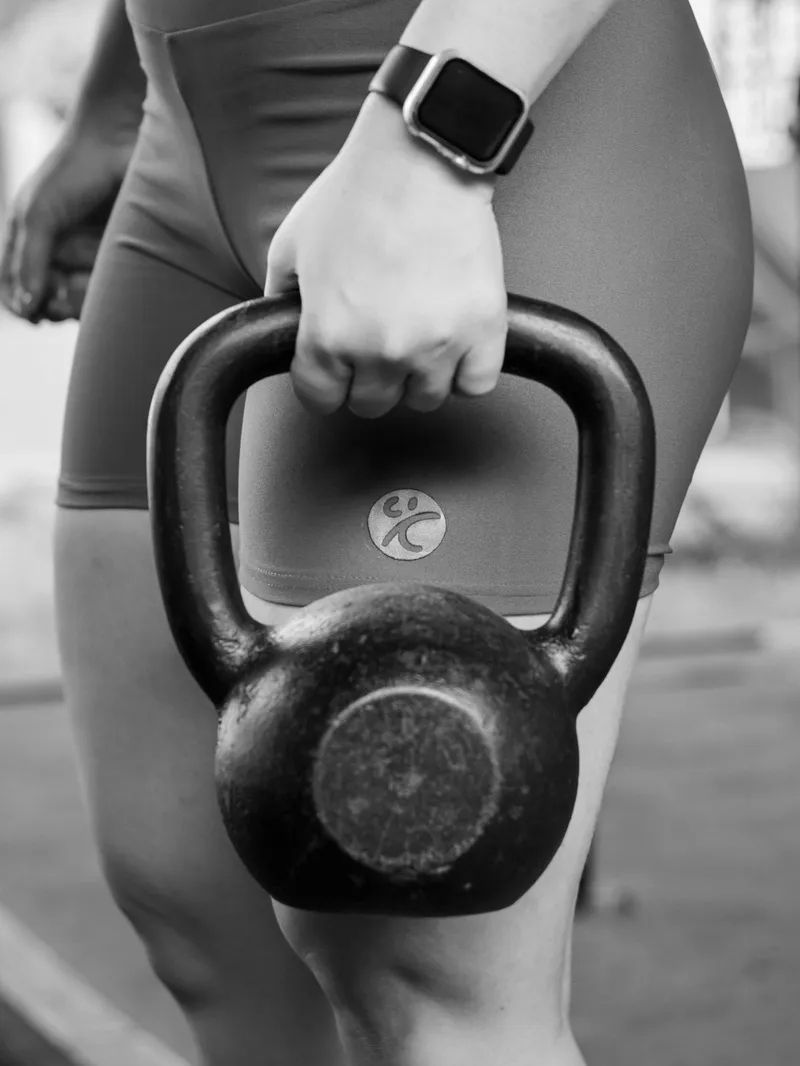 Woman performing kettlebell exercises at Forge Athletics during personal training session in Naples