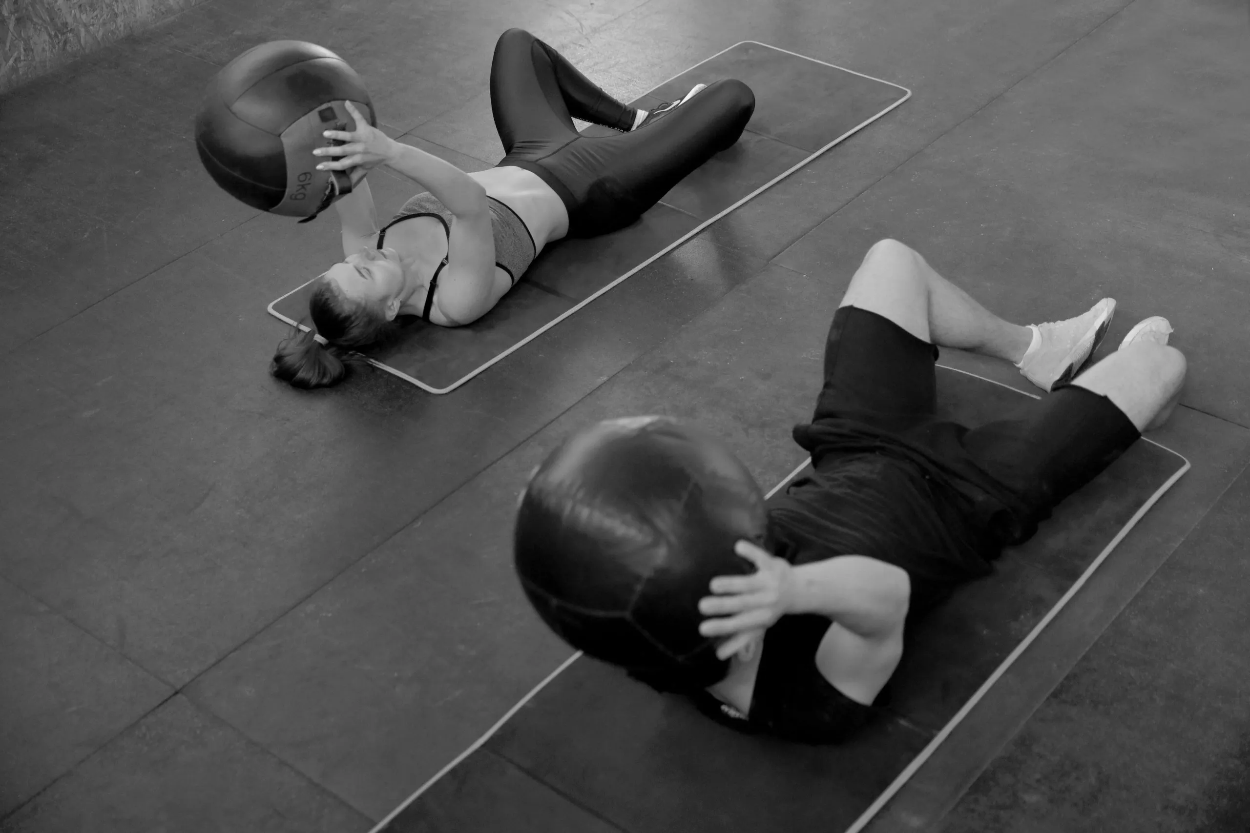 Group strength training session using med balls for core conditioning at Forge Athletics in Naples