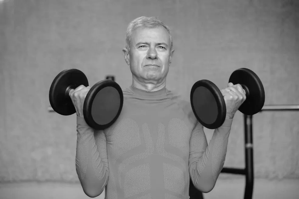 Senior performing strength training exercises with personal trainer at Forge Athletics in Naples, FL