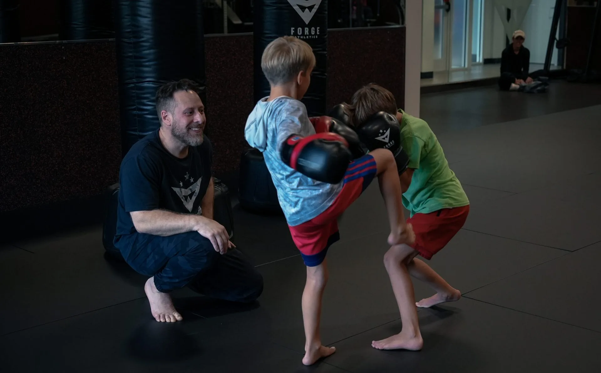 Forge Athletics summer camp Naples FL — coach teaching young boys martial arts at new gym space