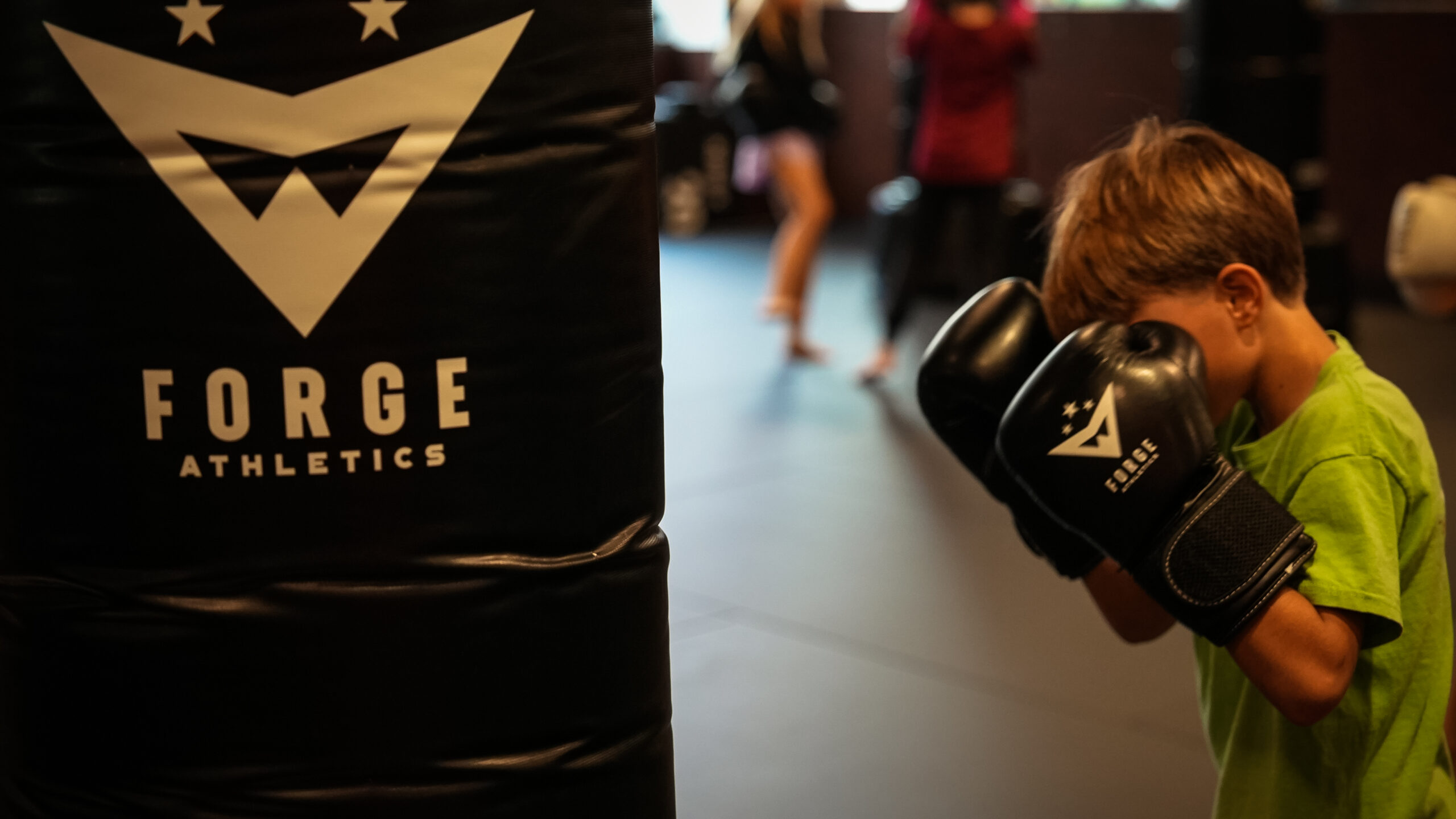 Confident young athlete at Forge Athletics with boxing gloves