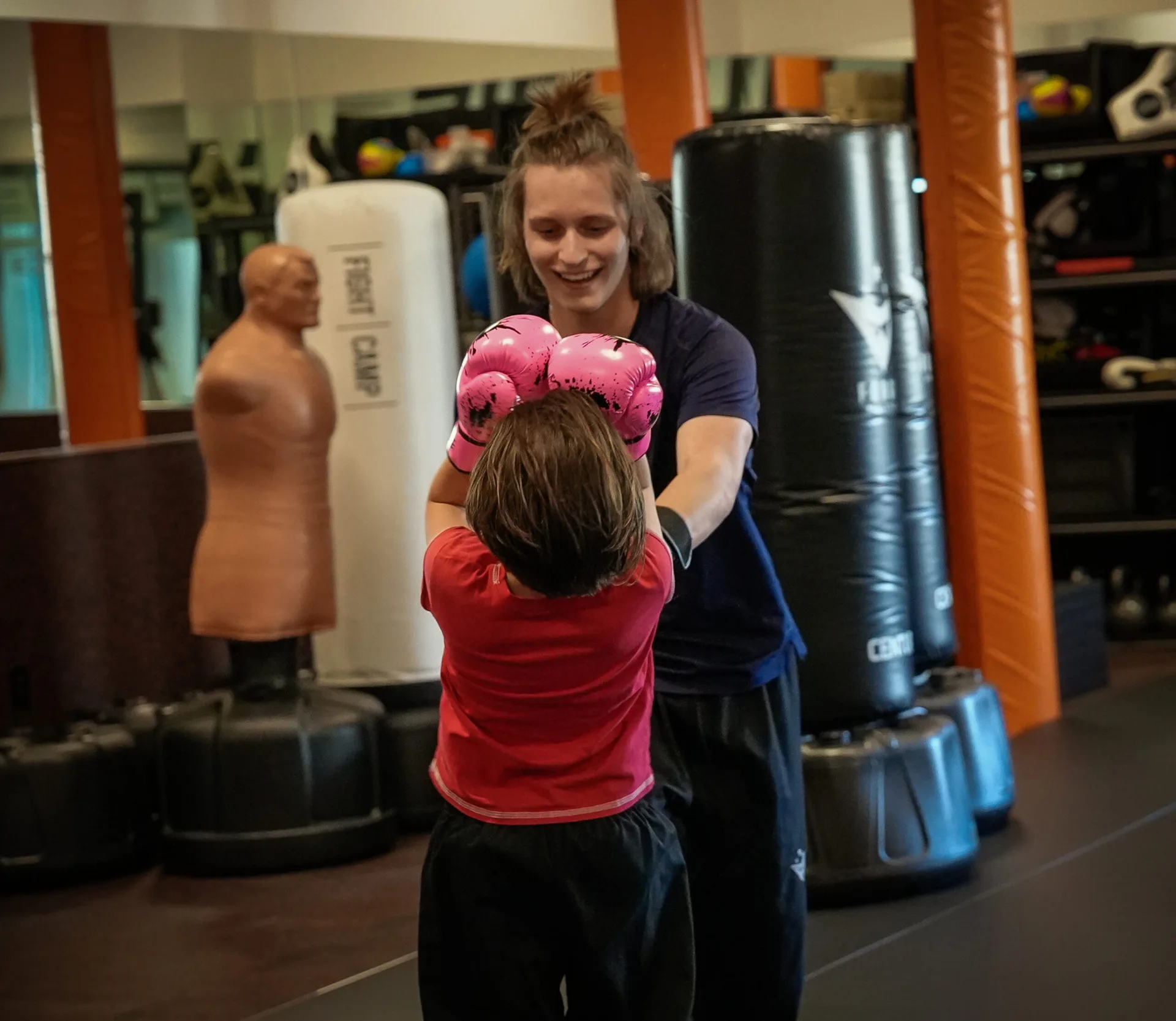 Shy young camper learning strikes in a low-pressure one-on-one with a Forge Athletics coach in Naples FL