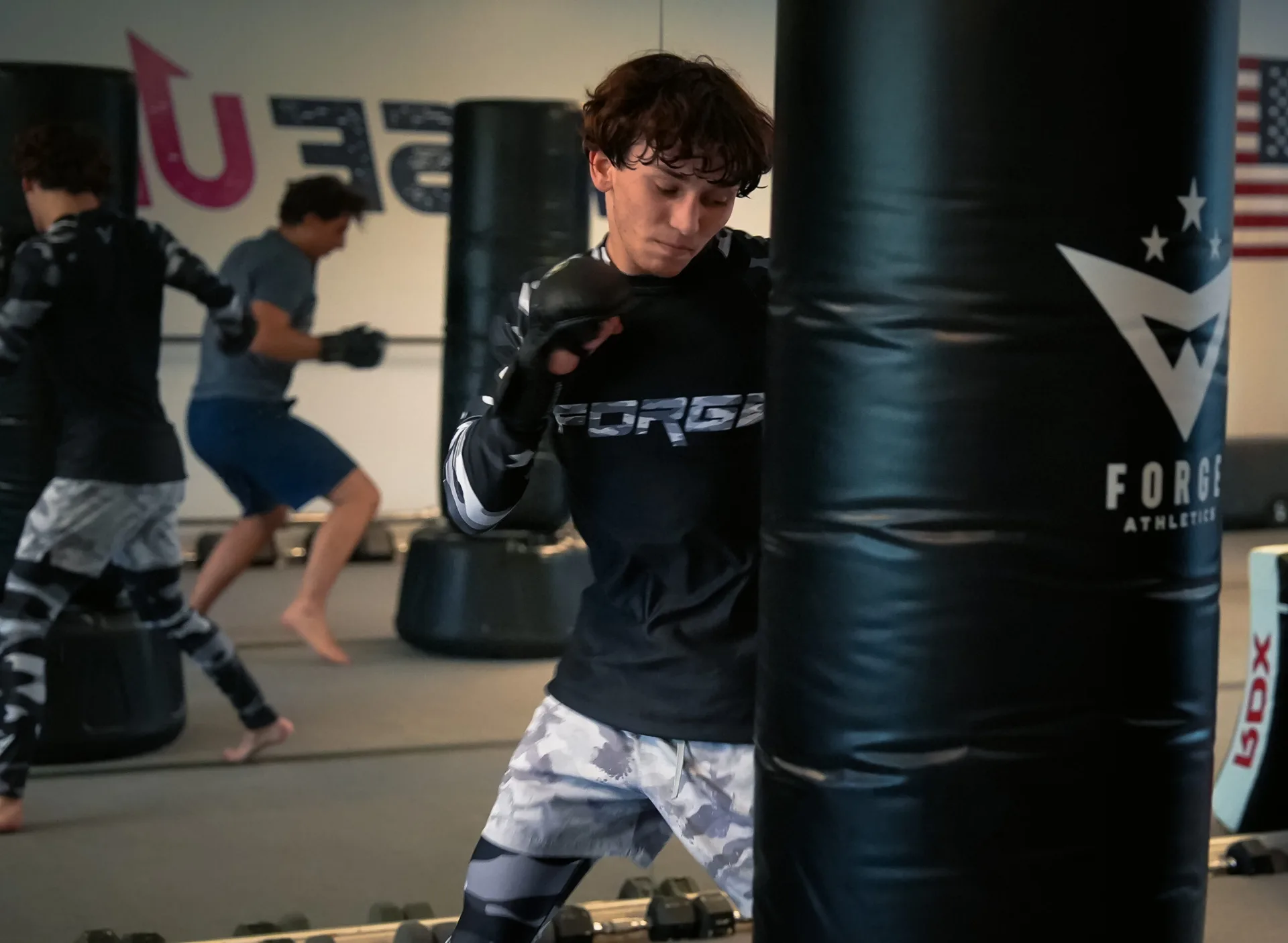 Teen working self-defense strikes on the heavy bag at Forge Athletics Naples FL