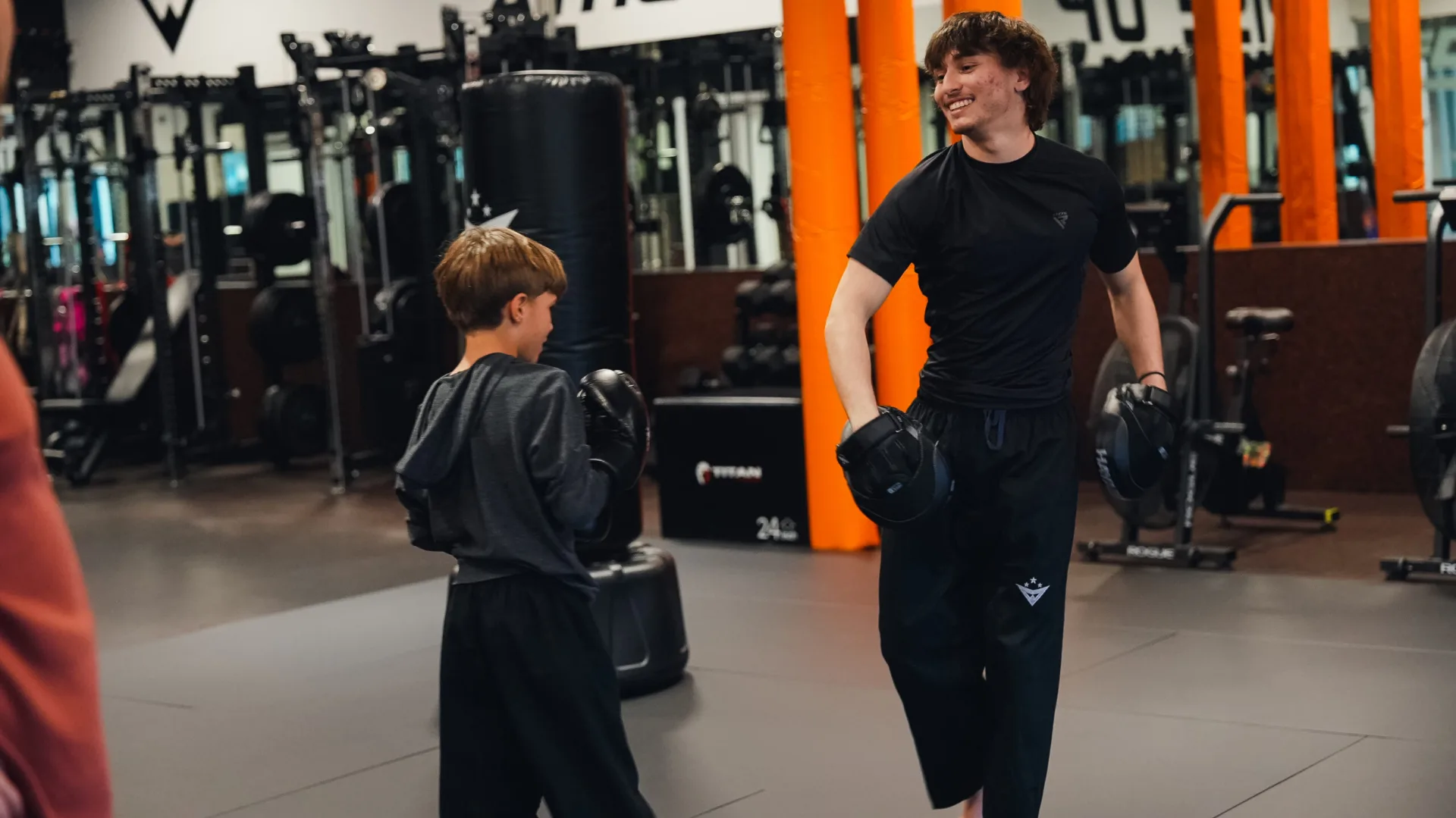 Teen camper striking the heavy bag at Forge Athletics Naples FL — 2026 summer camp enrollment